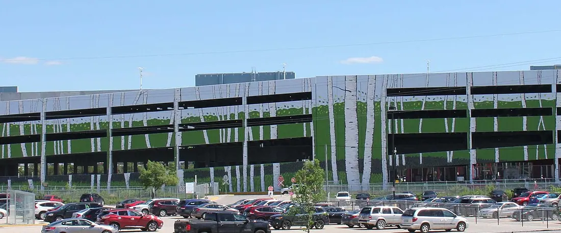 The north side of the Club Regent Casino complex in Winnipeg: its multi-level parkade wrapped in a birch-tree mural, above a full parking lot